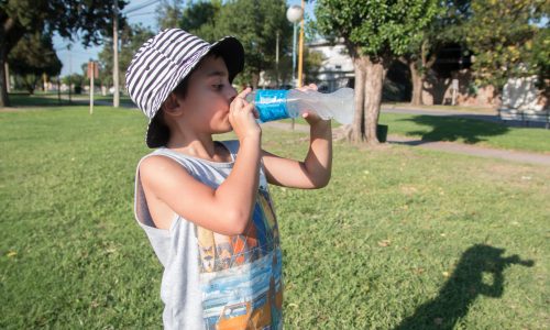 full-length-boy-drinking-water-park